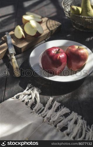 Sliced apples on a plate. Authentic light in garden