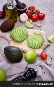 Sliced avocado on wooden cutting board at domestic kitchen.. Sliced avocado on wooden cutting board at domestic kitchen