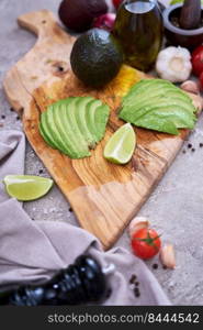 Sliced avocado on wooden cutting board at domestic kitchen.. Sliced avocado on wooden cutting board at domestic kitchen