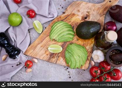 Sliced avocado on wooden cutting board at domestic kitchen.. Sliced avocado on wooden cutting board at domestic kitchen