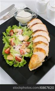 Sliced baked chicken breast with garnish a la Caesar.
