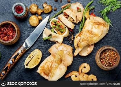 Sliced baked squid with vegetables on a slate board.Squid stuffed with mushrooms.Bbq calamary. Fried squids or calamary