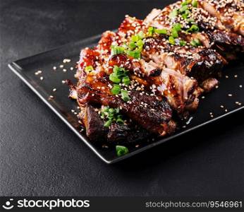 sliced BBQ pork ribs on black plate