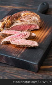 Sliced beef steak on the wooden cutting board