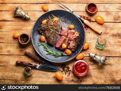 Sliced beef steak roasted with kumquat,rosemary and spices.Veal entrecote on a plate. Juicy beef steak with kumquat,top view