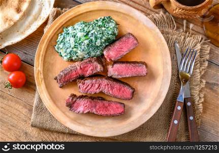 Sliced beef steak with creamy spinach
