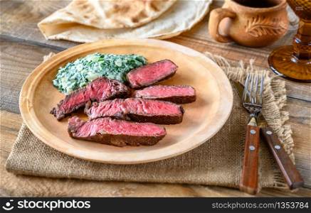 Sliced beef steak with creamy spinach