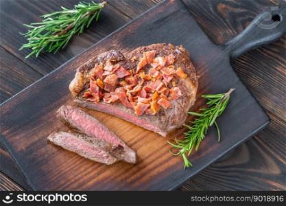 Sliced beef steak with crumbled bacon garnished with rosemary