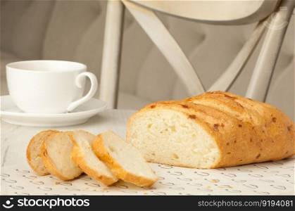 sliced bread and a cup of coffee on the table against the background of the chair. bread and a cup on the table