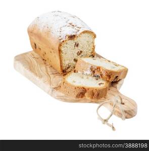 Sliced cake with raisins on a wooden cutting board, isolated on a white background