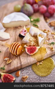 Sliced Camembert or brie cheese on wooden cutting board at domestic kitchen.. Sliced Camembert or brie cheese on wooden cutting board at domestic kitchen