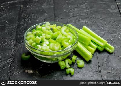Sliced celery in a bowl. On rustic background. Sliced celery in a bowl.