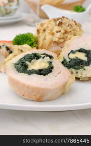 Sliced chicken roll stuffed with spinach and mozzarella and cheese with walnuts