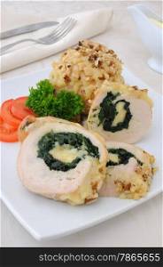 Sliced chicken roll stuffed with spinach and mozzarella and cheese with walnuts