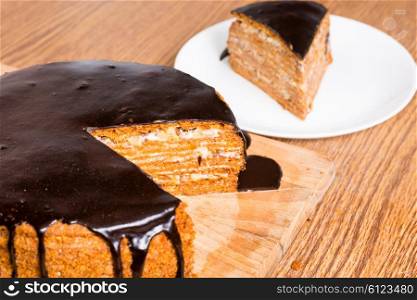 Sliced chocolate birthday cake on wooden table