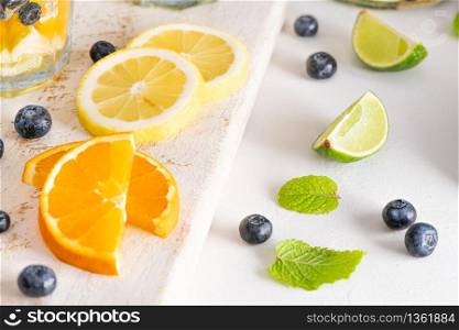 Sliced citrus fruits and blueberries on kitchen countertop background closeup