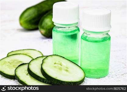 Sliced cucumber and a bottle of cucumber extract. Liquid cosmetics for skin care. Spa. Sliced cucumber and a bottle of cucumber extract. Liquid cosmetics for skin care.