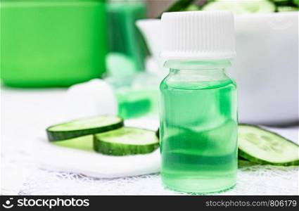 Sliced cucumber and a bottle of cucumber extract. Liquid cosmetics for skin care. Spa. Sliced cucumber and a bottle of cucumber extract. Liquid cosmetics for skin care.