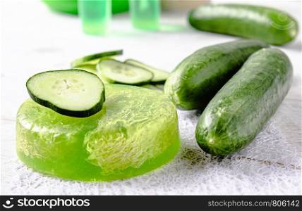 Sliced cucumber and soap on a white background. Home body care cucumber and care concept. Treatments with cucumber soap.. Sliced cucumber and soap on a white background. Home body care cucumber and care concept.