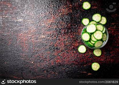 Sliced cucumbers in a glass bowl. Against a dark background. High quality photo. Sliced cucumbers in a glass bowl.