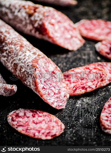 Sliced delicious salami sausage. On a black background. High quality photo. Sliced delicious salami sausage. On a black background.