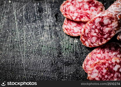 Sliced delicious salami sausage. On a black background. High quality photo. Sliced delicious salami sausage. On a black background.