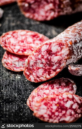 Sliced delicious salami sausage. On a black background. High quality photo. Sliced delicious salami sausage. On a black background.