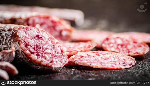 Sliced delicious salami sausage. On a black background. High quality photo. Sliced delicious salami sausage. On a black background.