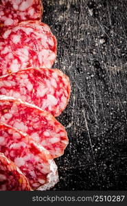 Sliced delicious salami sausage. On a black background. High quality photo. Sliced delicious salami sausage. On a black background.