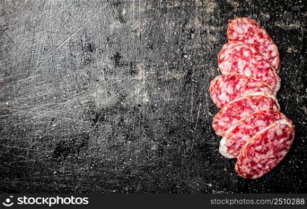 Sliced delicious salami sausage. On a black background. High quality photo. Sliced delicious salami sausage. On a black background.