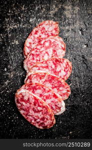 Sliced delicious salami sausage. On a black background. High quality photo. Sliced delicious salami sausage. On a black background.