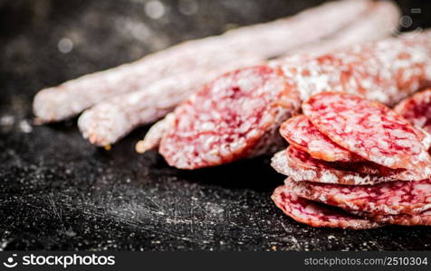 Sliced delicious salami sausage. On a black background. High quality photo. Sliced delicious salami sausage. On a black background.