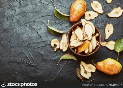 Sliced dried pear pieces.Dried pear or pear chips.Dried fruits.Copy space. Dried pears and fresh pears