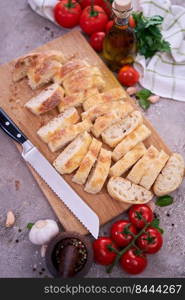 Sliced French bread baguette on wooden bread board.. Sliced French bread baguette on wooden bread board