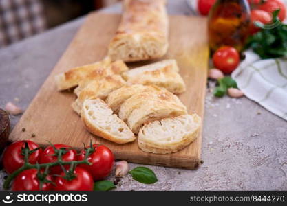 Sliced French bread baguette on wooden bread board.. Sliced French bread baguette on wooden bread board