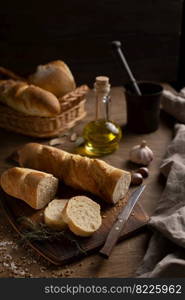 Sliced french bread with cutting board on wood table. Homemade bread at wooden tabletop as baking concept