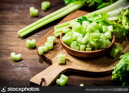 Sliced fresh celery on a cutting board. On a wooden background. High quality photo. Sliced fresh celery on a cutting board.