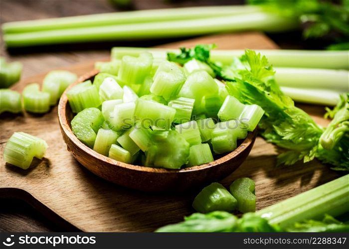 Sliced fresh celery on a cutting board. On a wooden background. High quality photo. Sliced fresh celery on a cutting board.