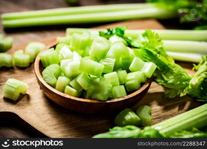 Sliced fresh celery on a cutting board. On a wooden background. High quality photo. Sliced fresh celery on a cutting board.