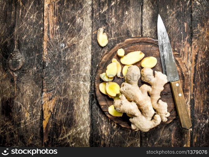 Sliced fresh ginger on the Board. On wooden background.. Sliced fresh ginger on the Board.