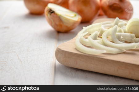 Sliced fresh onions on wooden background. Vegetables for a healthy diet. Vegan food. Yellow onion. Sliced fresh onions on wooden background. Vegetables for a healthy diet. Vegan food.