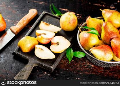Sliced fresh pear on a cutting board. Against a dark background. High quality photo. Sliced fresh pear on a cutting board.