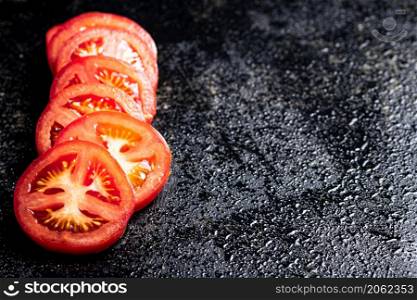 Sliced fresh tomatoes. On a black background. High quality photo. Sliced fresh tomatoes. On a black background.