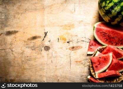Sliced fresh watermelon. On a wooden background.. Sliced fresh watermelon.