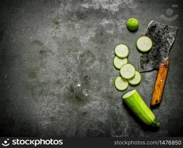 Sliced fresh zucchini old hatchet. On a stone background.. Sliced fresh zucchini old hatchet.