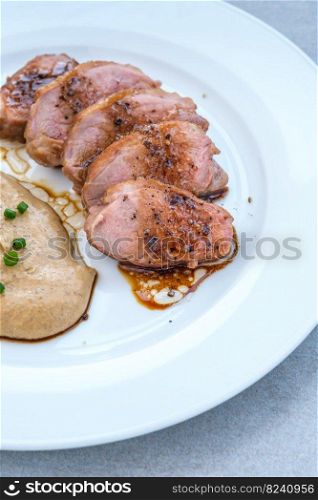 Sliced fried duck breast garnished with lentil puree