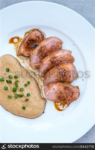 Sliced fried duck breast garnished with lentil puree