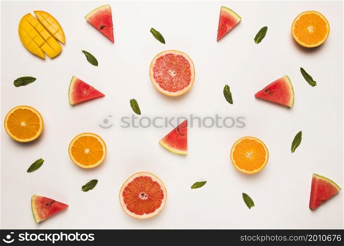 sliced grapefruit watermelon orange mango green leaves