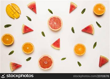 sliced grapefruit watermelon orange mango green leaves