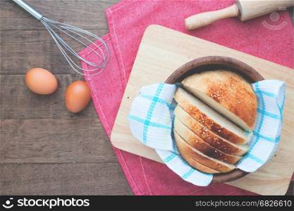 Sliced homemade bread with eggs on wood table with copy space, Flat lay